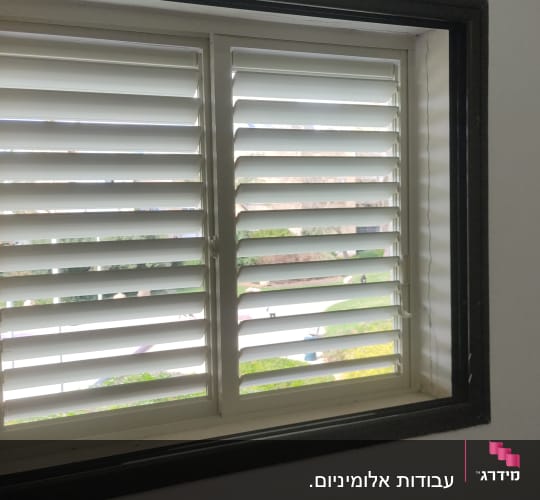 חלון עם תריסי אלומיניום לבנים